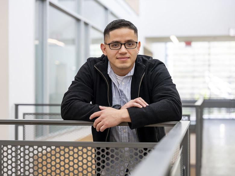 Adult student leans on railing in Gaige Building